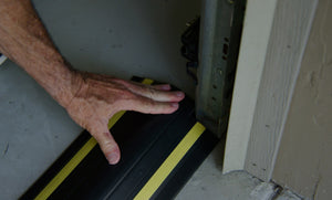 Ein mit Hand befestigte Garagentor-Wasserbarriere gegen ansteigendes Wasser auf dem Boden der Garage